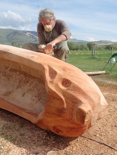 Churchill Clark sanding the dugout canoe.