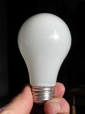 light bulb held by fingers.